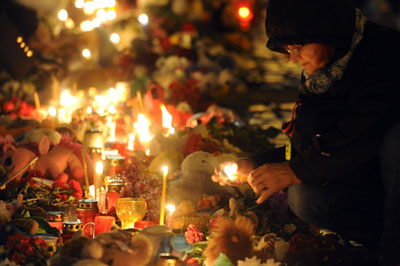A woman lights a candle at a makeshift memorial for the victims of a jetliner crash, at Dvortsovaya Square in  St Petersburg on Wednesday (AFP photo)