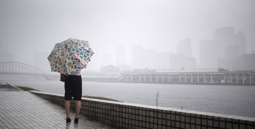 A woman protects herself from the rain with an umbrella in Tokyo on Saturday as the country braces for Typhoon Jongdari.  Local authorities issued early evacuation orders, with western areas recently devastated by floods and landslides (AFP photo)