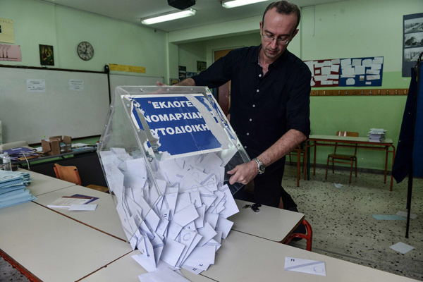 An election official opens a ballot box to count votes at a polling station in Thessaloniki on Sunday  (AFP photo)
