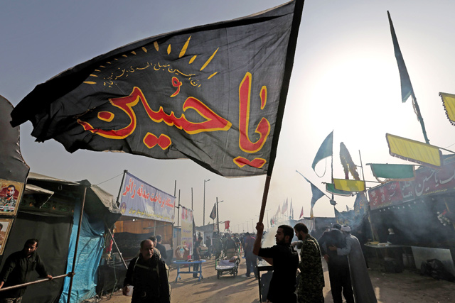 Iranian Shiite Muslim pilgrims wave flags at the Mehran border point between Iran and Iraq, as they head towards the central Iraqi shrine city of Karbala, on Sunday, ahead of the Arbaeen religious festival (AFP photo)