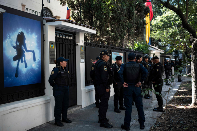 Riot police officers and members of the diplomatic police corps stand guard outside the Ecuadorian embassy in Mexico City on Saturday, following the severance of diplomatic relations between the two countries (AFP photo)