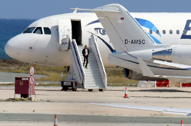A man believed to be the hijacker of the EgyptAir Airbus A-320, which was diverted to Cyprus, leaves the plane before surrendering to security forces after a six-hour stand-off on the tarmac at Larnaca airport's largely disused old terminal on Tuesday (AFP photo by George Michael)