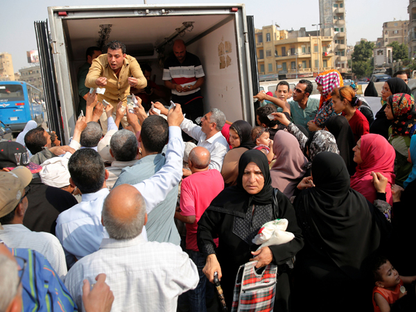 Locals gather to buy subsidised sugar from a government truck after a sugar shortage in retail stores across the country in Cairo, Egypt, October 14 (Reutes photo)