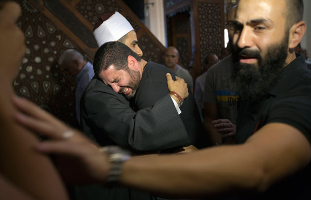 The Imam of Al Thawrah Mosque, Samir Abdel Bary, gives condolences to Tarek Abu Laban  (centre) who lost four relatives, all victims of Thursday's EgyptAir plane crash, at Al Thawrah Mosque in Cairo on Friday (AP photo by Amr Nabil)