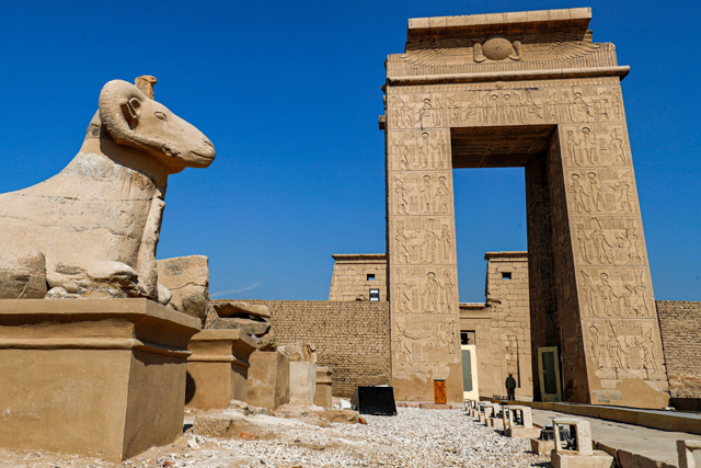 This photo taken on Friday shows a view of one of the ram-headed sphinxes along the ‘Rams Road’ (Sphinx dromos) outside the South Gate of the Temple of Karnak (background) in Egypt’s southern city of Luxor (AFP photo)