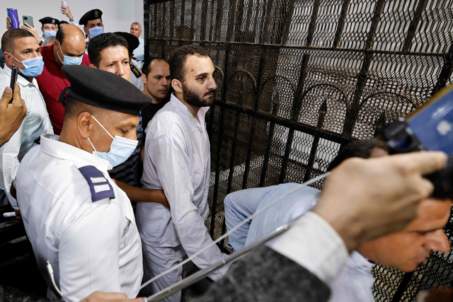 Egyptian Mohamed Adel (centre), the presumed murderer of university of Mansoura student Naira Ashraf, is surrounded by guards as he is taken out of the defender’s box, after his first trial session at the Mansoura courthouse, some 145km north of the capital Cairo, on Sunday (AFP photo)