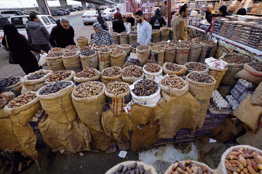 In this photo taken on March 22 a young worker stacks trays of freshly-baked bread at a bakery at downtown Cairo. In a time of dire economic trouble, Egyptians are holding fast to the Ramadan tradition of charity, with both donors and those in need pinning hopes on holiday generosity (AFP photo)