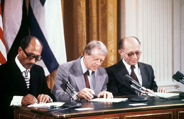 In this file photo taken on September 17, 1978, Egyptian President Anwar Al Sadat (left), Israeli Premier Menachem Begin (right) and US President Jimmy Carter  sign a peace agreement in the East Room of the White House (AFP photo) 