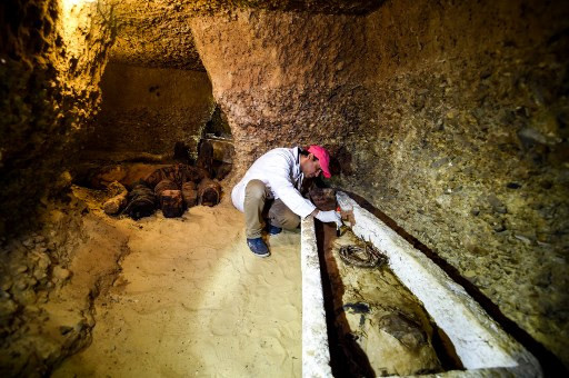 An archeologist brushes a newly-discovered mummy laid inside a sarcophagus, part of a collection found in burial chambers dating to the Ptolemaic era (323-30BC) at the necropolis of Tuna El Gebel in Egypt's southern Minya province, about 340 kilometres south of the capital Cairo, on February 2 (AFP photo)