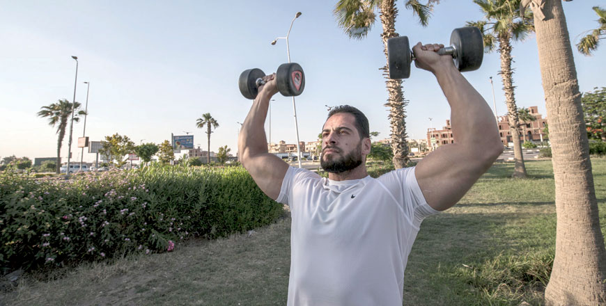 Bodybuilder coach Mohamed Nassim, a 33-year-old Syrian exile who settled in Cairo after escaping his war-torn country with the start of the conflict in 2011, takes part in a training session in a public park in October city in Giza governorate on outskirt of the Egyptian capital on June 15 (AFP photo)