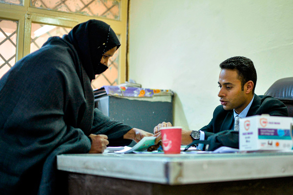 A woman voter, mask-clad due to the COVID-19 coronavirus pandemic, registers as she arrives at a polling station in Esna, about 55 kilometres south of Egypt’s southern city of Luxor on Saturday  (AFP photo)