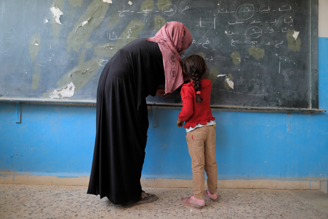 A girl attends her first class immediately after she got registered at the school in Hazima, north of Raqqa, Syria, on August 21 (Reuters photo)