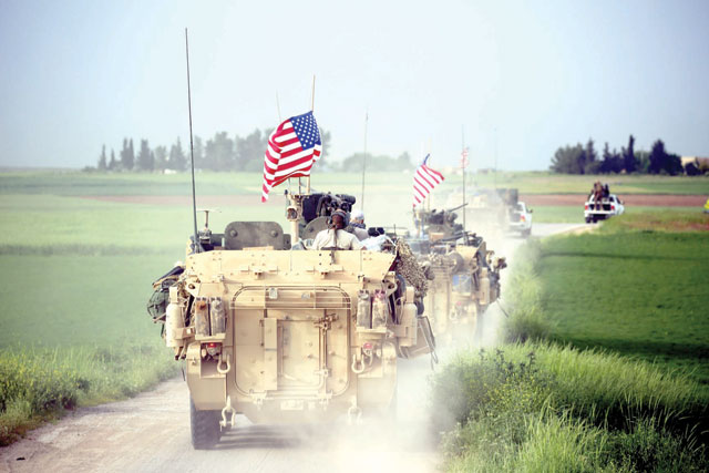 This file photo taken on April 28  shows US forces, accompanied by Kurdish People's Protection Units fighters, driving their armoured vehicles near the northern Syrian village of Darbasiyah, on the border with Turkey (AFP photo)