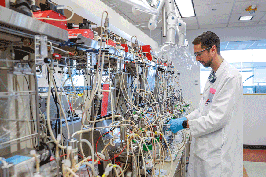 Adam Thompson, senior scientist, works at LanzaTech lab on November 28,  in Skokie, Illinois. In the dozens of jars of the laboratory of the LanzaTech company, in the suburbs of Chicago, a beige liquid bubbles continuously: tiny bacteria gorge themselves on gas, which they ingest to recycle it (AFP photo)