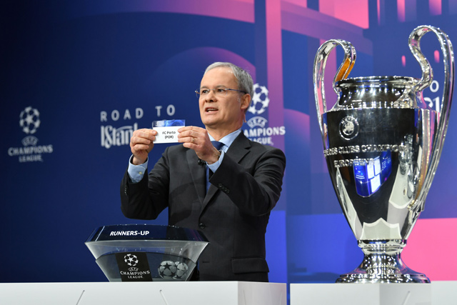   This handout photograph taken and released on Monday by the Union of European Football Associations (UEFA) shows UEFA competitions director Giorgio Marchetti revealing the slip of FC Porto during the draw for the round of 16 of the UEFA Champions League football tournament at the UEFA headquarters in Nyon  (AFP photo)