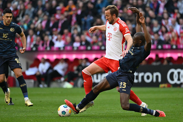 Bayern Munich’s English forward #09 Harry Kane (C) and Mainz’s French midfielder #23 Josuha Guilavogui vie for the ball during the German first division Bundesliga football match FC Bayern Munich vs 1 FSV Mainz 05 in Munich, southern Germany, on Saturday (AFP photo)