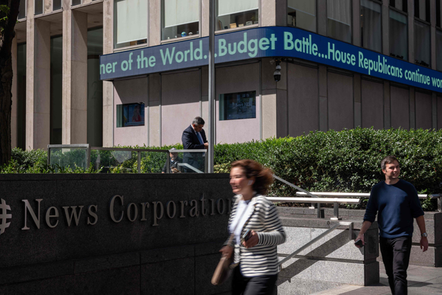 People walk by the News Corp. headquarters in midtown Manhattan on Thursday in New York City (AFP photo)