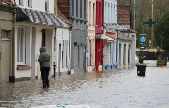 A resident of Neuville-sous-Montreuil, northern France, stands in front of her flooded house on Monday (AFP photo)