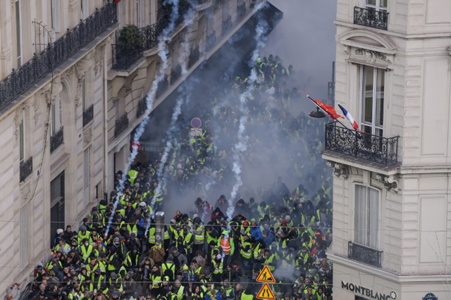 Shouts of 'Macron, resign' mingled with the tear gas near the Champs-Elysees Avenue in Paris on Saturday (AFP photo)