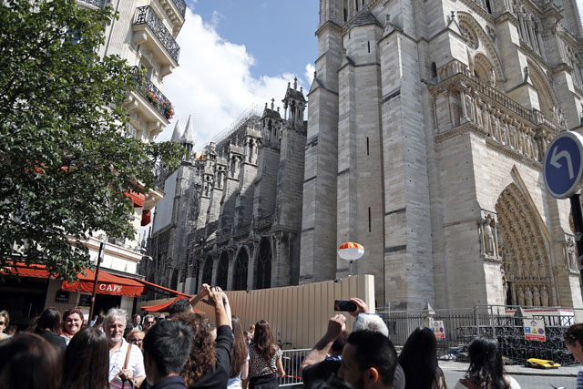People use their mobile phone to take images of Notre-Dame de Paris cathedral, in Paris, on Saturday (AFP photo)