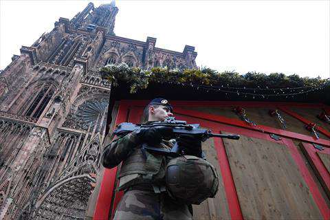 A French soldier stands guard at the Christmas market in front of the cathedral, on Wednesday, as policemen conduct a search in order to find the gunman who opened fire near a Christmas market the night before in Strasbourg, eastern France (AFP photo)