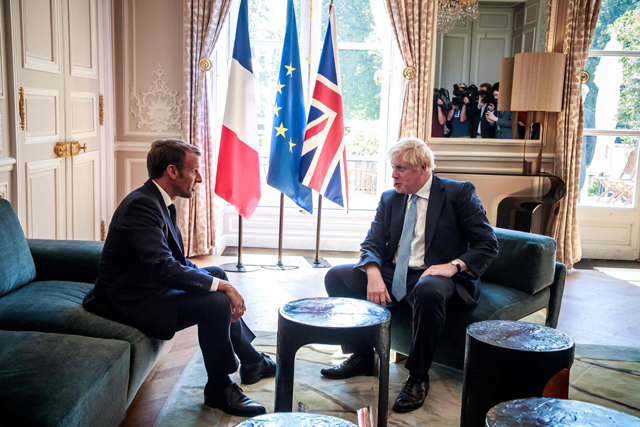 French President Emmanuel Macron (left) and Britain's Prime Minister Boris Johnson  talk during their meeting at the Elysee Palace in Paris, France, on Thursday (AFP photo)