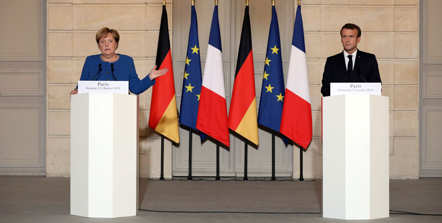 French President Emmanuel Macron (left) and German Chancellor Angela Merkel give a press conference at the Elysee Palace in Paris on Sunday as they meet for a working dinner ahead of the EU summit (AFP photo)
