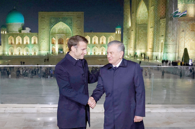 France’s President Emmanuel Macron (left) shakes hands with Uzbek President Shavkat Mirziyoyev  at the Registan square in Samarkand, on Wednesday (AFP photo)