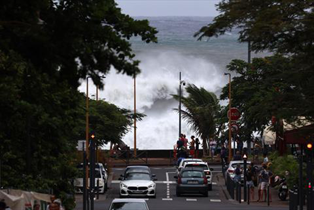 People watches waves crashing in Saint-Denis de la Reunion on Sunday as authorities on France’s Indian Ocean Reunion Island urged residents to stock up on food and water ahead of a tropical storm that risks strengthening to a cyclone before it hits later tonight (AFP photo)