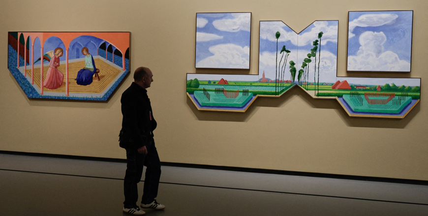 A visitor looks at paintings by British painter David Hockney ahead of the opening of the exhibition titled ‘David Hockney 25’ at the Louis Vuitton Foundation in Paris, on Monday (AFP photo)