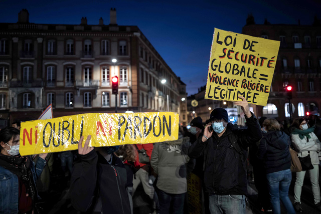 Protesters hold signs reading ‘Neither forgotten nor forgiven’ and ‘Overall security law = legitimised police violence’ during a demonstration on Tuesday in Toulouse, south-western France (AFP photo)