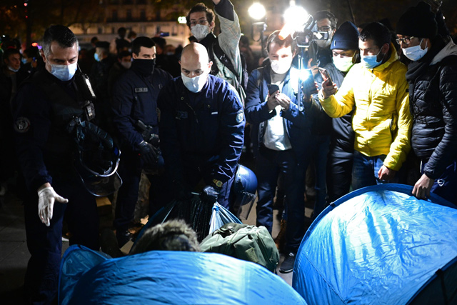 French gendarmes evacuate a makeshift tent camp set up by migrants, officials and ONG volunteers on Republique Square in Paris, on Sunday  (AFP photo)