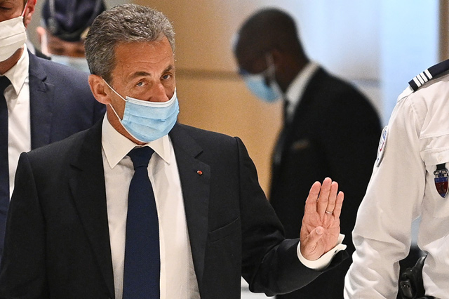 Former French president Nicolas Sarkozy gestures as he arrives at the Paris court house to hear the final verdict in a corruption trial on Monday (AFP photo)