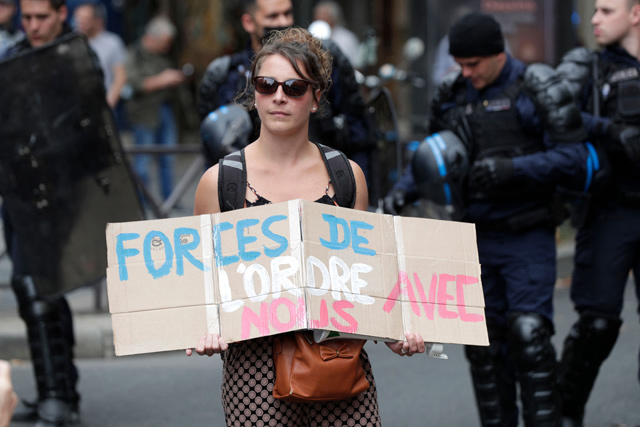 A demonstrator holds up an anti-vaccination placard that reads, ‘Justice is with us’ during a protest against the compulsory COVID-19 vaccination for certain workers and the compulsory use of the health pass called for by the French government in Paris, on Saturday (AFP photo)