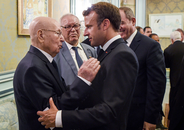 In this file photo taken on July 27, 2019, French President Emmanuel Macron greets Algeria's interim president Abdelkader Bensalah during the late Tunisian president Beji Caid Essebsi's state funeral at the presidential palace in the Tunisian capital (AFP photo)