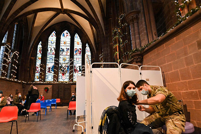 A soldier from the Corps of the Royal Electrical and Mechanical Engineers (REME) administers a dose of the Covid-19 vaccine at a vaccination clinic set up at Chester Cathedral on Thursday (AFP photo)