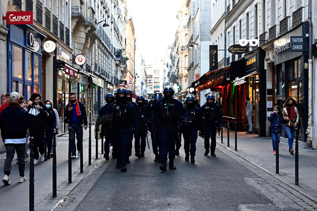 French anti-riot policemen walk a street of Paris among bystanders on Saturday as convoys of protesters so called ‘Convoi de la Liberte’ arrived in the French capital (AFP photo)  