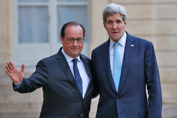 French President Francois Hollande (left) and US Secretary of State John Kerry pose upon arrival at the Elysee Palace, in Paris, France, Tuesday (AP Photo)