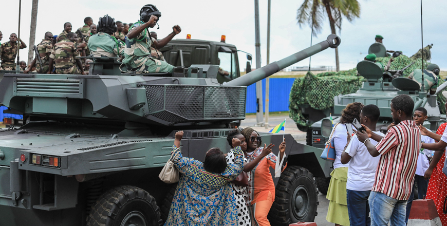 People wave and take photos with men in uniform, moments after the swearing-in ceremony of Brice Oligui Nguema, inaugurated as Gabon's interim president, in Libreville, on Monday (AFP photo)
