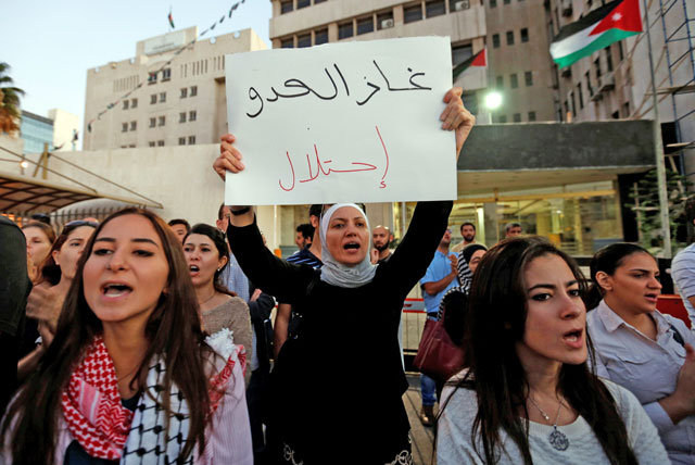 Activists take part in a sit-in outside the Energy Ministry headquarters in Amman to protest against a government agreement to import natural gas from Israel on Tuesday. The placard reads: ‘The enemy's gas is occupation’ (Reuters photo by Muhammad Hamed)