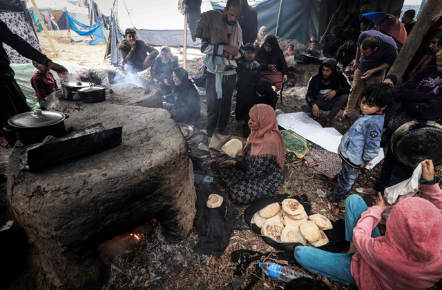 A women makes bread in ovens at a makeshift camp housing displaced Palestinians, in Rafah, in the southern Gaza Strip (AFP photo)