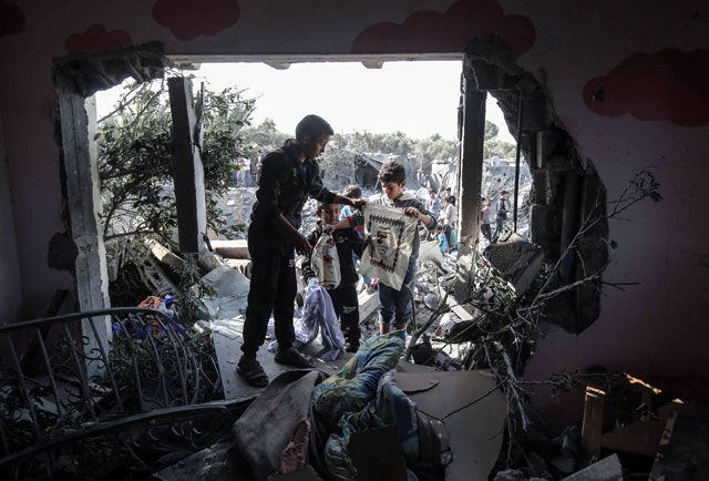 Palestinians search through the destruction following an Israeli air strike on Thursday in Khan Younis in the southern Gaza Strip (AFP photo)