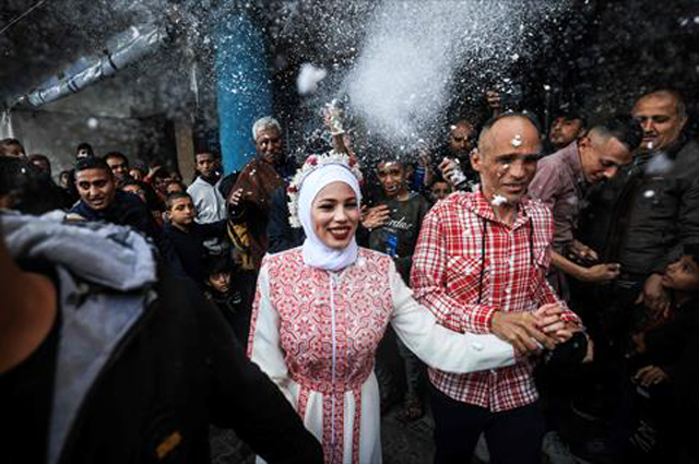 Palestinian bride Afnan Jibril is escorted by her father during her wedding at the UNRWA School in the Al Salam neighbourhood of Rafah, southern Gaza Strip, on Friday (AFP photo)