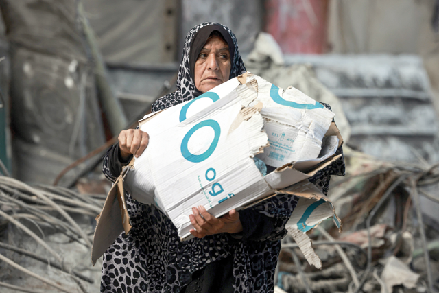 A woman carries cardboard boxes to use for a fire in Rafah on the southern Gaza Strip on January 14, 2024, as the ongoing Israeli war on Gaza enters its 100th day (AFP photo)