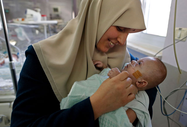 Gazan Jumana Daoud carries her seven-month-old daughter Maryam at Makassed Hospital in Israeli-occupied East Jerusalem on Monday, as they meet for the first time since the baby’s premature birth (AFP photo)