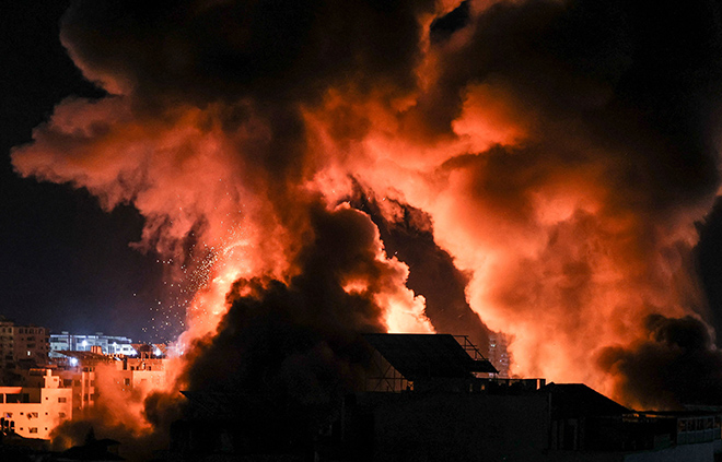 Explosions light-up the night sky above buildings in Gaza City as Israeli forces shell the Palestinian enclave, early on Tuesday (AFP photo)