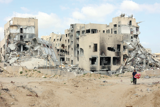 A Palestinian man carries belongings in Beit Lahya in the northern Gaza Strip on Saturday, amid the ongoing conflict between Hamas and Israel (AFP photo)
