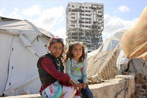 Palestinian girls sit outside their makeshift tent during Eid Al Fitr, which marks the end of the holy fasting month of Ramadan, in Gaza City on March 30, 2025 (AFP photo)