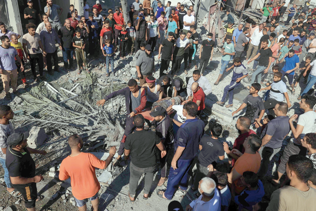 A Palestinian is stretchered away after being pulled out from under the rubble of a building following an Israeli air strike in Rafah, in the southern of Gaza Strip, on Monday (AFP photo)