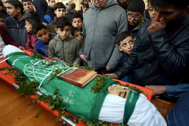 Boys gather around the body of Palestinian teen Abdul Raouf Salha during his funeral in the northern Gaza Strip, on Monday (Reuters photo)